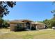 Inviting single-story home featuring a screened front entry and manicured lawn at 31728 Nutmeg Ave, Eustis, FL 32736