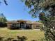 A charming single-story home features a large front yard, screened porch, and well-maintained landscaping at 31728 Nutmeg Ave, Eustis, FL 32736