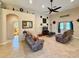 Bright living room with tile flooring, neutral walls, a ceiling fan, and comfortable reclining sofas at 31728 Nutmeg Ave, Eustis, FL 32736