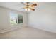 Empty bedroom with neutral colored walls, a window, and a ceiling fan with lights at 3294 Shelby St, The Villages, FL 32162