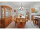 Cozy dining area featuring a wooden table, chandelier, and natural light streaming in from sliding glass doors at 3294 Shelby St, The Villages, FL 32162