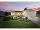 Charming single-story home at dusk featuring well-maintained landscaping, a two-car garage, and great curb appeal at 3294 Shelby St, The Villages, FL 32162