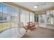 The sunroom has a ceiling fan, carpeted floor, bench, and outdoor views at 3294 Shelby St, The Villages, FL 32162