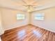 Cozy bedroom showcasing attractive wood-look floors, a ceiling fan, and two windows for natural light at 33415 Picciola Dr, Fruitland Park, FL 34731