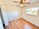 Bright bedroom featuring a window, ceiling fan, wood-look flooring, and closet with folding doors at 33415 Picciola Dr, Fruitland Park, FL 34731