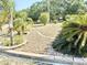 Landscaped front yard featuring rock beds and lush tropical plants, adding curb appeal to the property at 33415 Picciola Dr, Fruitland Park, FL 34731