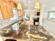 Stylish kitchen with granite countertops, tiled backsplash, stainless appliances, wood cabinets and a view of living room at 33415 Picciola Dr, Fruitland Park, FL 34731