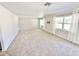 Spacious living room with neutral carpet, two large windows, and a centrally located air conditioning vent at 33415 Picciola Dr, Fruitland Park, FL 34731