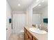 Well-lit bathroom with a single sink vanity, white shower curtain, and a neutral color palette for a clean, modern feel at 3396 Greenacres Ter, The Villages, FL 32163