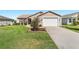 Single-story home featuring an attached garage, tidy landscaping, and a well-kept lawn at 3396 Greenacres Ter, The Villages, FL 32163