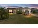 Inviting single-story home at dusk, showcasing manicured landscaping and cozy curb appeal at 3396 Greenacres Ter, The Villages, FL 32163