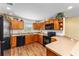 Updated kitchen with wood cabinets, black appliances, and a breakfast bar at 3396 Greenacres Ter, The Villages, FL 32163