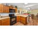 Open kitchen layout with wood cabinets, a breakfast bar, and adjacent dining area at 3396 Greenacres Ter, The Villages, FL 32163