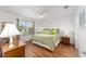 Cozy main bedroom with a ceiling fan, natural light, and wood-look floors at 3396 Greenacres Ter, The Villages, FL 32163