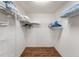 Spacious walk-in closet featuring a wood floor, white walls, and metal racks for ample storage and organization at 3396 Greenacres Ter, The Villages, FL 32163