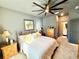 Comfortable bedroom with a large bed, ceiling fan, and a view of an en-suite bathroom at 34004 Sky Blossom Cir, Leesburg, FL 34788