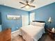 Cozy bedroom featuring blue walls, plush carpet, and a large window at 34004 Sky Blossom Cir, Leesburg, FL 34788