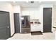 Bright kitchen featuring stainless steel refrigerator, white cabinets, and contrasting dark gray door frames at 34004 Sky Blossom Cir, Leesburg, FL 34788