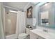 Comfortable bathroom featuring a shower with curtain, white vanity with white sink, and mirror at 34407 Island Dr, Leesburg, FL 34788
