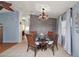 Elegant dining area featuring a round glass table, stylish chandelier, and views into the adjacent living spaces at 34407 Island Dr, Leesburg, FL 34788