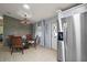 Cozy dining area features a glass table and modern chandelier, adjacent to the kitchen and stainless refrigerator at 34407 Island Dr, Leesburg, FL 34788
