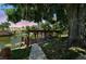 Picturesque waterfront scene featuring a boat dock under mature trees at sunset at 34407 Island Dr, Leesburg, FL 34788