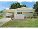 Inviting single-story home featuring a screened carport and lovely landscaping, enhancing curb appeal at 34407 Island Dr, Leesburg, FL 34788