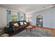Cozy living room with wood floors, bright windows, a plush leather sofa, and stylish decor at 34407 Island Dr, Leesburg, FL 34788