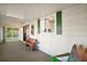Inviting screened porch area with wood bench, coastal decor, and view into bright kitchen at 34407 Island Dr, Leesburg, FL 34788