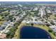 Aerial view of a quiet residential community with winding roads, surrounded by many trees and a pond at 3723 Belle Rose Dr, Leesburg, FL 34748