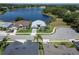 Stunning aerial view of lakefront home featuring lush landscaping and a paver driveway at 3723 Belle Rose Dr, Leesburg, FL 34748