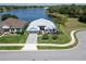 Stunning lakefront house with manicured lawn, tropical palm trees, and serene waterfront views at 3723 Belle Rose Dr, Leesburg, FL 34748