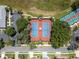 Aerial view of community tennis courts surrounded by trees, providing ample recreational space at 3723 Belle Rose Dr, Leesburg, FL 34748