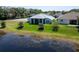 Lakefront home boasts a covered patio and meticulously maintained backyard with mature trees at 3723 Belle Rose Dr, Leesburg, FL 34748