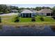 Beautiful backyard featuring a screened lanai, lush landscaping, and tranquil lake views at 3723 Belle Rose Dr, Leesburg, FL 34748
