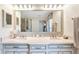 Bright bathroom with double sinks, granite countertops, and a large framed mirror at 3723 Belle Rose Dr, Leesburg, FL 34748