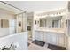 This is a bright bathroom featuring double vanities, decorative mirrors and a glass enclosed shower at 3723 Belle Rose Dr, Leesburg, FL 34748
