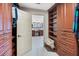 This organized closet features wood cabinets and shelving leading to the primary bathroom at 3723 Belle Rose Dr, Leesburg, FL 34748