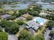 Aerial view of a community center, tennis courts, pool, and lake providing diverse recreational options at 3723 Belle Rose Dr, Leesburg, FL 34748