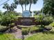 The Plantation at Leesburg entrance sign, lush landscaping, and mature palm trees create a grand arrival at 3723 Belle Rose Dr, Leesburg, FL 34748