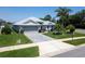 Beautifully landscaped home with palm trees, manicured lawn, and stylish brick driveway at 3723 Belle Rose Dr, Leesburg, FL 34748