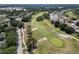 Aerial shot of a lush golf course with rolling greens, mature trees, and scenic fairways on a sunny day at 3723 Belle Rose Dr, Leesburg, FL 34748