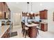 Open-concept kitchen featuring granite counters, a central island, and stainless steel appliances at 3723 Belle Rose Dr, Leesburg, FL 34748
