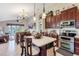 Kitchen with granite countertops, island seating, and stainless steel appliances overlooking the living room and outdoor views at 3723 Belle Rose Dr, Leesburg, FL 34748