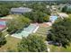 Aerial view showcasing lawn bowling and tennis courts surrounded by trees near the community pool at 3723 Belle Rose Dr, Leesburg, FL 34748