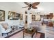 Bright living room features neutral paint, fan, and seamless flow into an open kitchen space at 3723 Belle Rose Dr, Leesburg, FL 34748