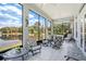 Enclosed patio featuring large picture windows with views of the lake and cushioned patio furniture at 3723 Belle Rose Dr, Leesburg, FL 34748