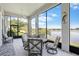 Enclosed patio featuring large picture windows with views of the lake and cushioned patio furniture at 3723 Belle Rose Dr, Leesburg, FL 34748