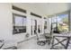 Enclosed patio with lake view featuring large picture windows and cushioned patio furniture at 3723 Belle Rose Dr, Leesburg, FL 34748
