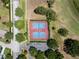 Aerial shot of two blue and red tennis courts with surrounding parking and trees on a sunny day at 3723 Belle Rose Dr, Leesburg, FL 34748